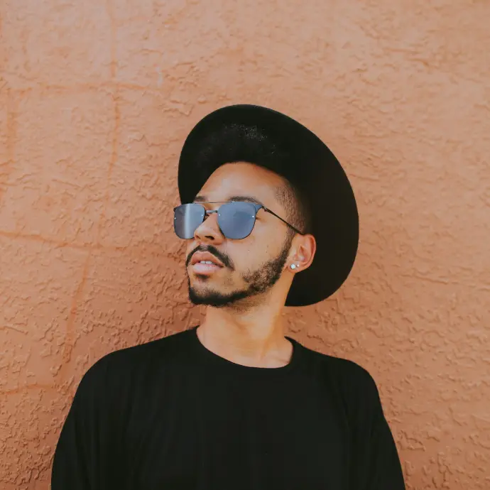 man leaning on brown wall